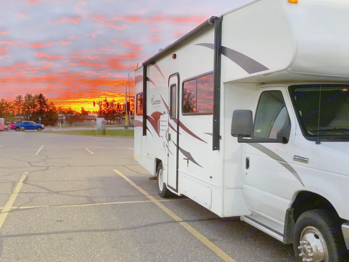 White RV rental (Coachmen Freelander) parked under a stunning orange and red sunset. Perfect for memorable road trips!. Coachman Freelander 27QB 2011