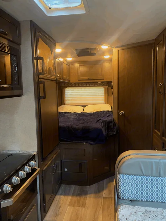 Step inside this inviting RV rental: a cozy interior with kitchen, bedroom, and dining area, perfect for road trips.. Thor Freedom Elite 2019