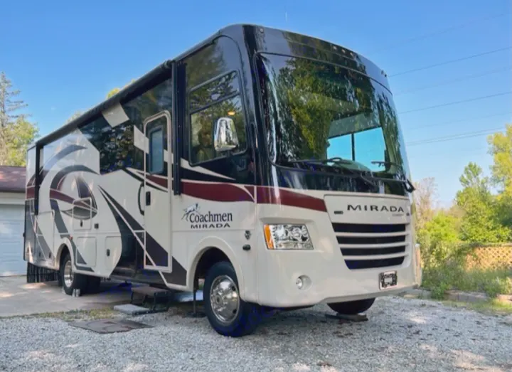 A large cream and black Coachmen Mirada motorhome, perfect for an RV rental getaway, parked outdoors.. Coachman Mirada 2018