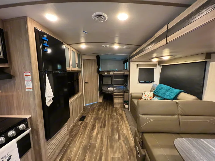 Spacious, modern RV rental interior featuring a full kitchen, living area, and bunk beds, perfect for family adventures.. Keystone Passport 2022