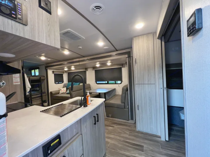 This RV rental offers a spacious and modern interior with a well-equipped kitchen, dinette, and sofa.. Keystone Passport 2022