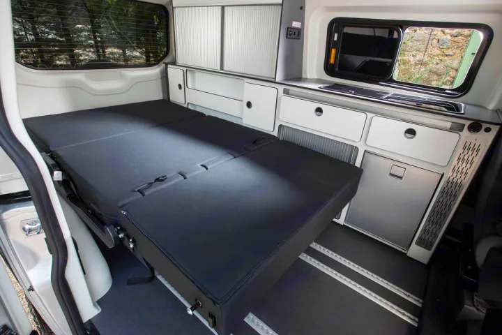 RV rental interior: cozy camper van with a folded-out bed, kitchenette, and storage.. Panama P10+ 2023