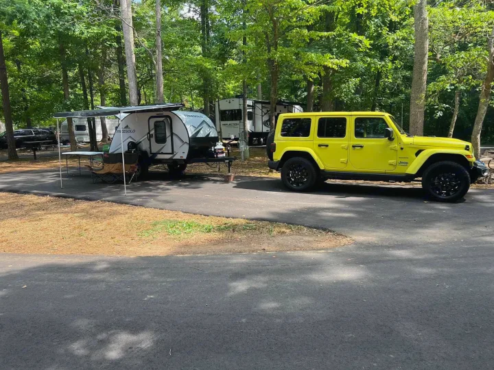 Yellow Jeep & FREESOLO teardrop RV/trailer at a wooded campsite, showcasing a great option for an rv rental adventure.. Braxton Creek Free Solo 2022