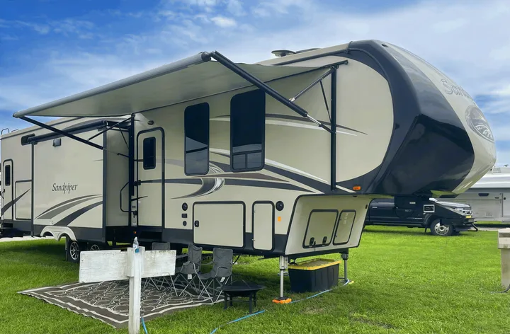 This Sandpiper fifth-wheel RV rental, with its extended awning and outdoor living space, is perfectly set up for camping.. Forest River Sandpiper 2018