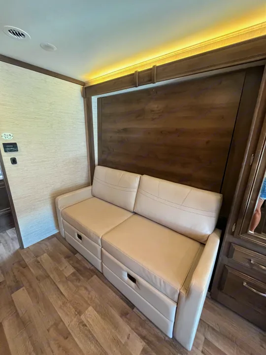 RV rental: Modern interior with a comfortable pull-out sofa, under-seat storage drawers, wood paneling, and ambient lighting.. Jayco Redhawk 2021