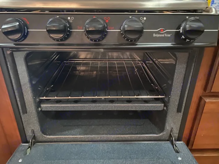 An open Wedgewood Vision oven with two racks visible inside an RV rental kitchen, ready for cooking.. Tioga Fleetwood 2011
