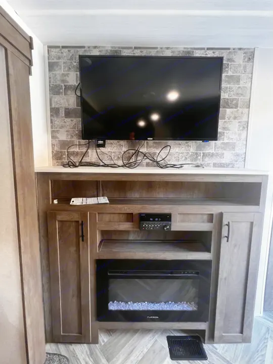 RV rental living area with a built-in entertainment center, including TV, fireplace, and sound system.. Forest River Evo 2020
