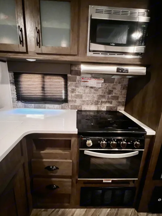 RV rental interior: A fully equipped kitchen with microwave, stovetop, oven, and ample counter space.. Forest River Evo 2020