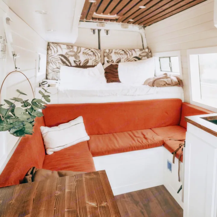 This rv rental interior offers a comfortable bed, U-shaped seating, a small kitchen, and a dining table.. Mercedes Sprinter 2013