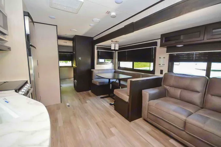 Spacious RV rental interior featuring a modern dinette, comfy sofa, and compact kitchen area. Perfect for your next adventure.. Jayco Jay Flight 2022