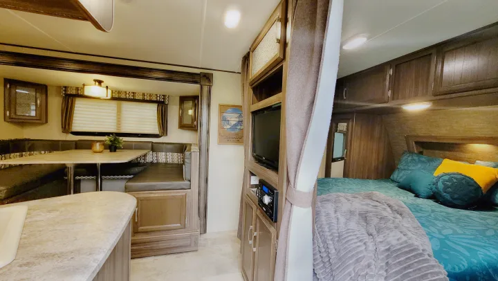 Cozy RV rental interior with dining, kitchen, entertainment, & bedroom areas for comfortable travel.. Coachmen Apex 2018