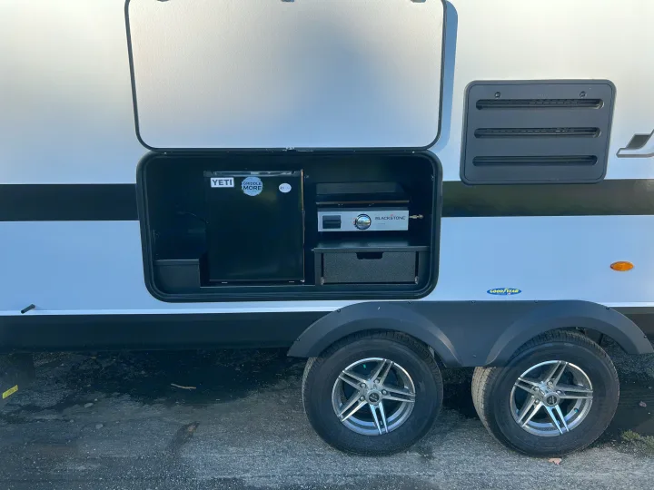 Outdoor kitchen set up in an RV rental with a Yeti mini-fridge and Blackstone griddle, perfect for camping meals.. Jayco Jay Feather 2022