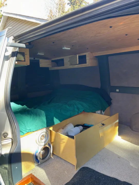 Explore this cozy RV rental's interior: comfy bed, custom wood storage, speakers, and a pull-out drawer.. Gmc Custom 1995