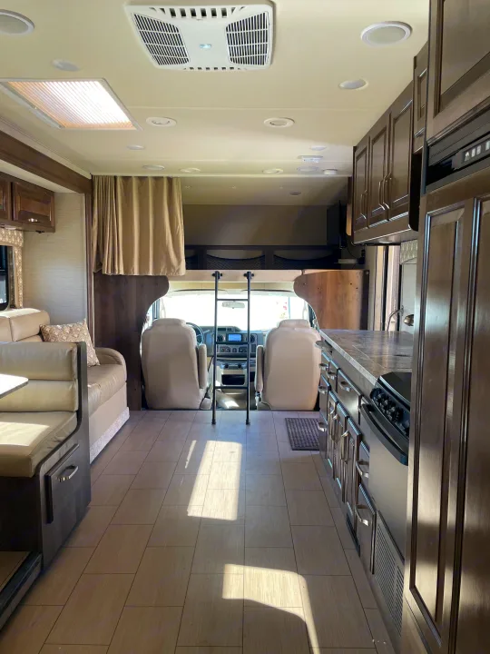 Spacious RV rental interior: kitchen, dinette, and overhead bunk above the driver's cabin for travel comfort.. Jayco Greyhawk 2018