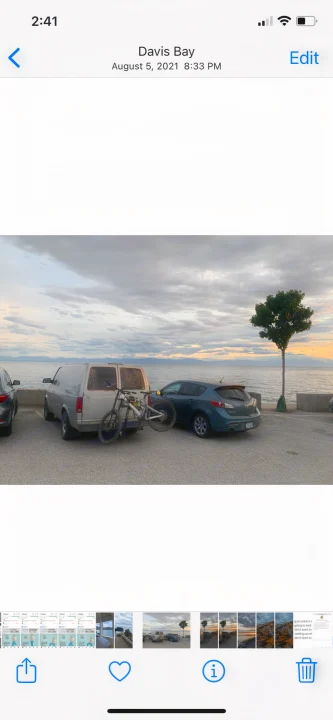 Davis Bay: An RV rental-style van with a bike and car parked by the serene bay at dusk, captured on a phone.. Gmc Custom 1995