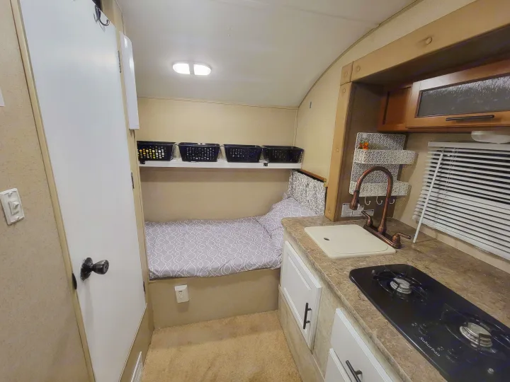 RV rental features: compact kitchen with stovetop & sink, comfy bed, storage baskets, and lighting.. R-Pod R-Pod Trailer 2015