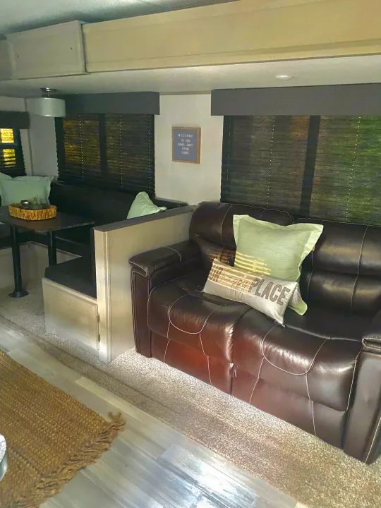 Relaxing RV rental interior features a cozy dinette and plush leather sofa. Ideal for travel comfort.. Forest River Tracer 2021