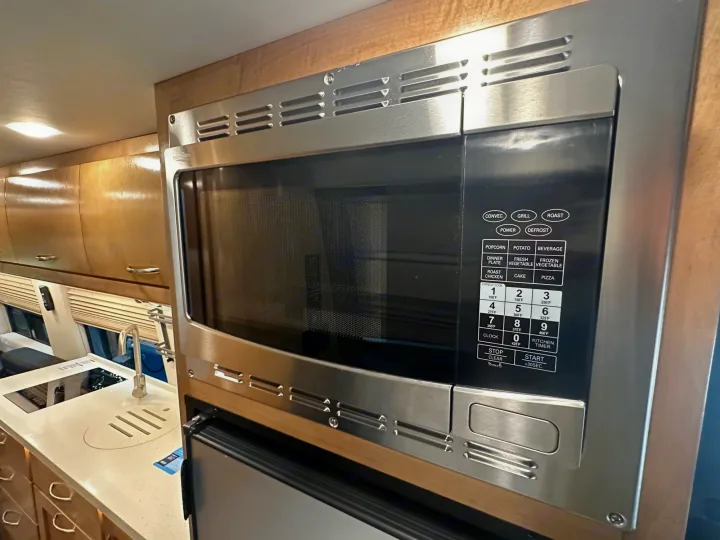 Stainless steel microwave/convection oven in an RV rental kitchen, featuring a full control panel and sleek design.. Coachmen Other 2022