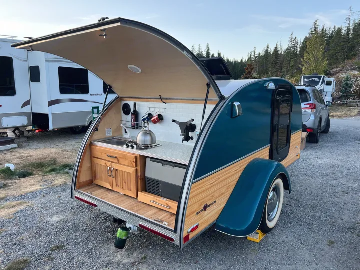 Explore the outdoors with this teardrop RV rental, featuring a complete rear kitchen for convenient camping.. Little Guy Silver Shadow 2016