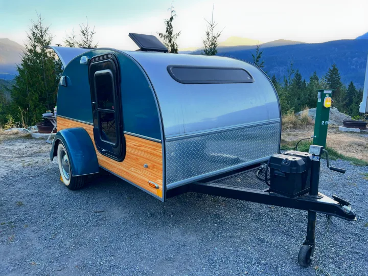 Teardrop RV rental parked at a scenic mountain campsite (29) with trees, ideal for outdoor travel.. Little Guy Silver Shadow 2016