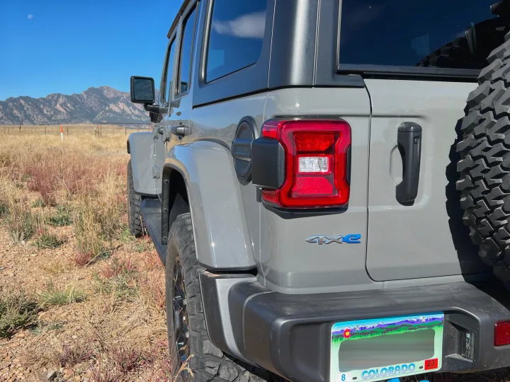 Gray Jeep Wrangler 4xe in Colorado's outdoors with mountains & moon. Perfect for adventure, just like an RV rental journey.. Jeep Wrangler 2022