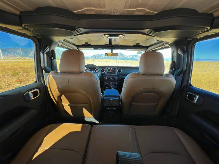 Inside a Jeep SUV, ready for your RV rental adventure. Tan leather seats, spacious interior, & scenic mountain views.. Jeep Wrangler 2022