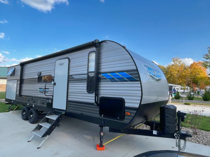 A modern gray and black Salem travel trailer, steps extended, ideal for your next rv rental adventure, parked outdoors.. Forest River Salem 2021