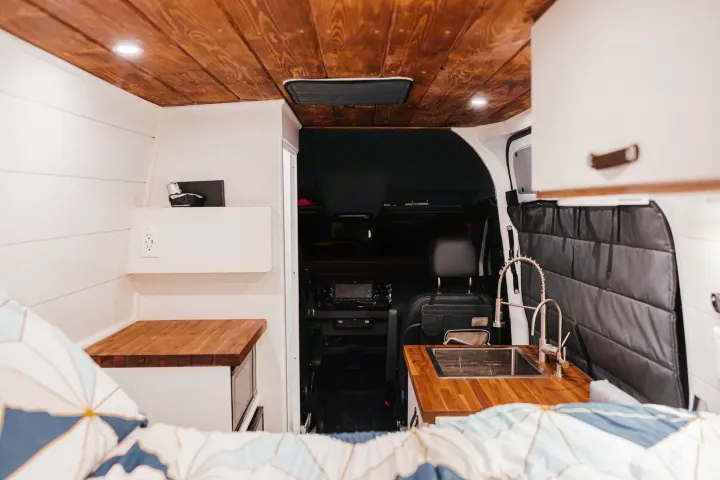Cozy camper van interior for your next RV rental adventure, featuring a compact kitchen and comfy bed.. Mercedes-Benz Sprinter RV Motorhome Campervan 2022