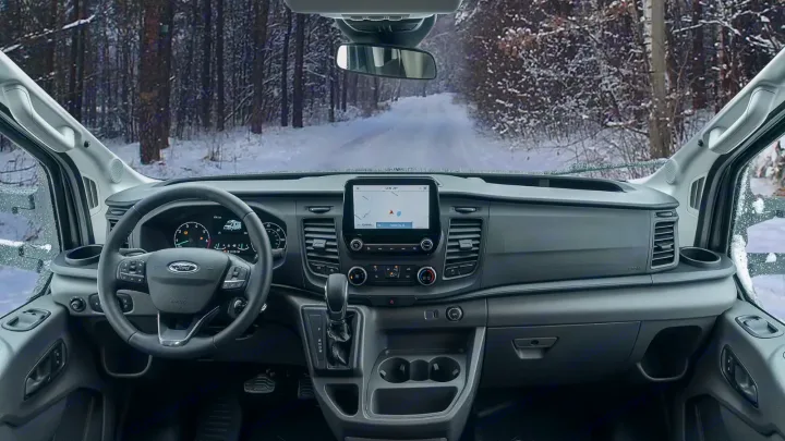 Ford RV rental cockpit on a winter road. Features modern dashboard, touchscreen navigation, and ample storage.. WINNEBAGO EKKO 2023