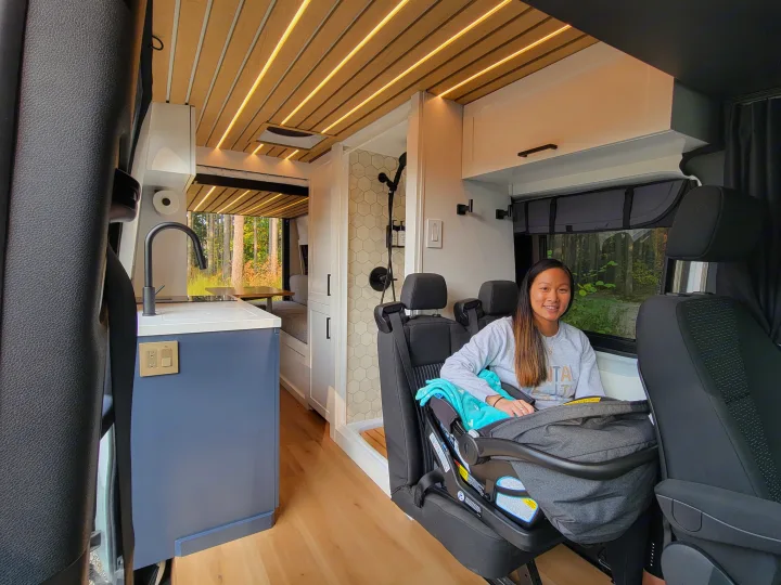 Modern RV rental: woman & baby in comfy seats, full kitchen & tiled shower. Ideal for family travel adventures.. Mercedes-Benz Sprinter 2021