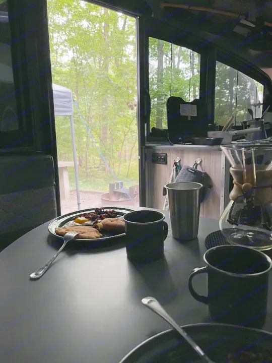 Cozy RV rental breakfast: pancakes, eggs, & coffee with a view of our forest campsite & fire pit.. Airstream Basecamp 2022