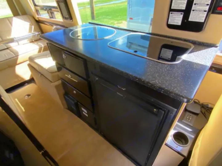 Experience comfort in this RV rental's kitchen: a compact countertop with a sink, cooktop, under-counter fridge, and drawers.. Mercedes Sprinter 2015