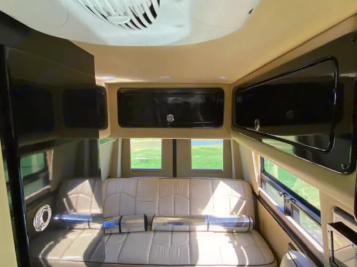 Cozy RV rental interior showing a comfortable seating area, overhead storage, and scenic windows for your next adventure.. Mercedes Sprinter 2015