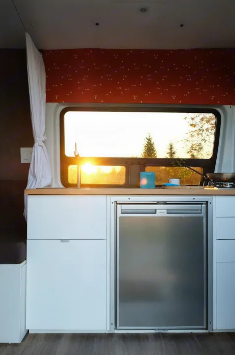 Enjoy stunning sunsets in your rv rental's cozy kitchen. This campervan features a sink, fridge, and cooktop for mobile living.. Mercedes-Benz Sprinter 2017