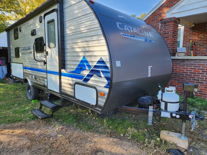 This Coachmen Catalina Summit Series travel trailer RV rental, parked on grass, awaits its next journey.. Forest River Coachmen Catalina Summit 2022