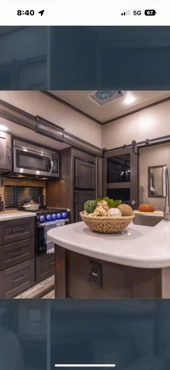 Modern RV kitchen with microwave, stove, and sink. Fully equipped for comfortable living during your RV rental.. Grand Design Reflection 2022