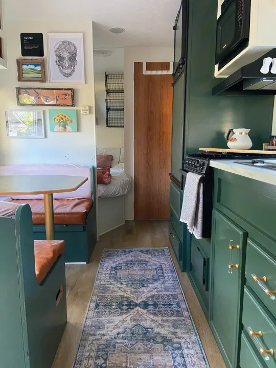Explore this stylish RV rental! Features a compact kitchen with green cabinets, a dining booth, & peek into the cozy bedroom.. Jayco Jay Flight 2007