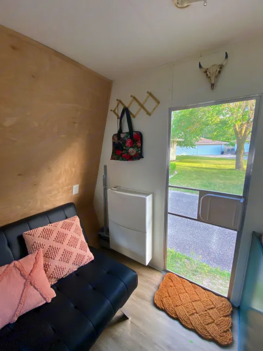 Cozy RV rental with black futon, wood walls, functional storage, & decorative skull by the door.. Jayco Jay Flight 2007