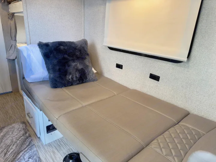 RV rental: Light-toned interior with a long, taupe upholstered dinette bed, dark pillow, pull-down blind, and base storage.. Forest River Rockwood GeoPro 2019