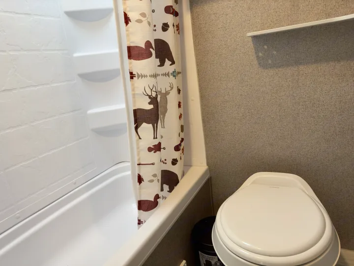 RV rental bathroom features: white shower with wildlife curtain and a compact toilet.. Forest River Rockwood GeoPro 2019