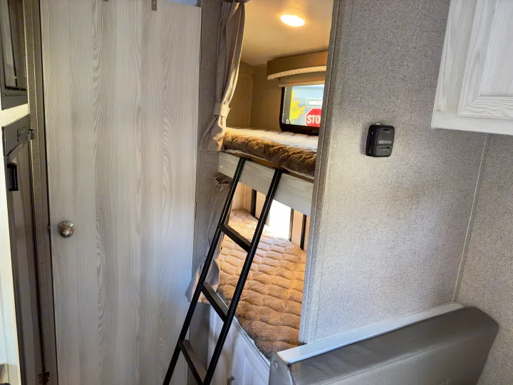 Experience comfort in this RV rental's sleeping area featuring upper/lower bunk beds, a ladder, window, and thermostat.. Forest River Rockwood GeoPro 2019