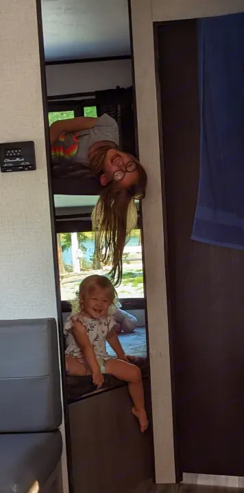 RV rental: Two happy girls, one upside down from a top bunk, the other sitting on a lower bunk, reflected in a mirror.. Highland Ridge RV Open Range 2022