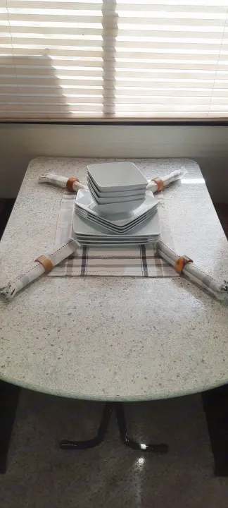 Comfortable RV rental dining area: Table set with white plates, striped napkins. Sunlight streams through window blinds.. Keystone RV Bullet Ultra Lite 2016