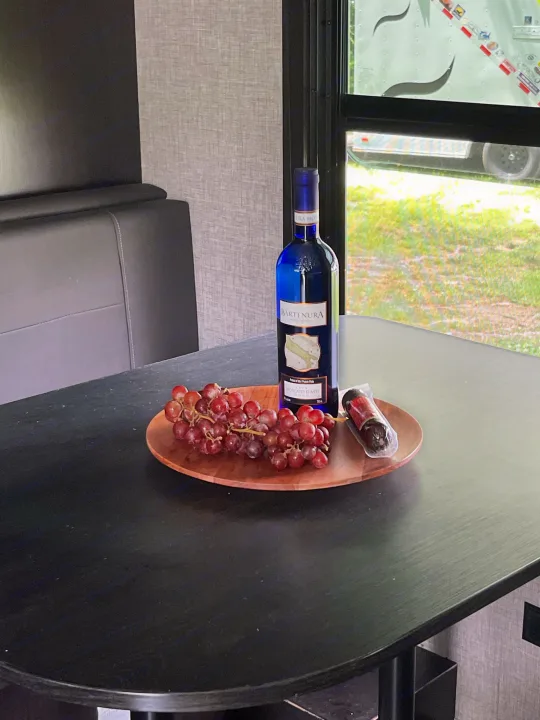 Relaxing in an RV rental: Bartenura wine, red grapes, and salami on a wooden platter for a cozy snack.. Jayco Jay Flight 2017