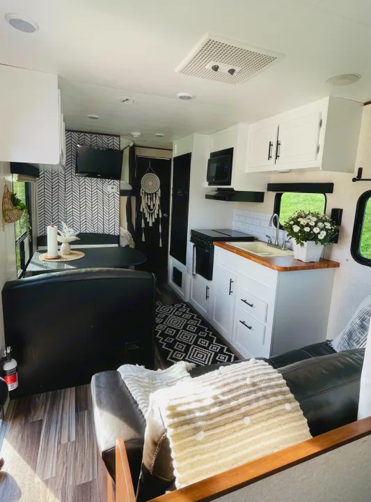 Modern black & white RV rental interior featuring a full kitchen, dining nook, and cozy living area with chic decor.. Jayco Jay Flight 2017