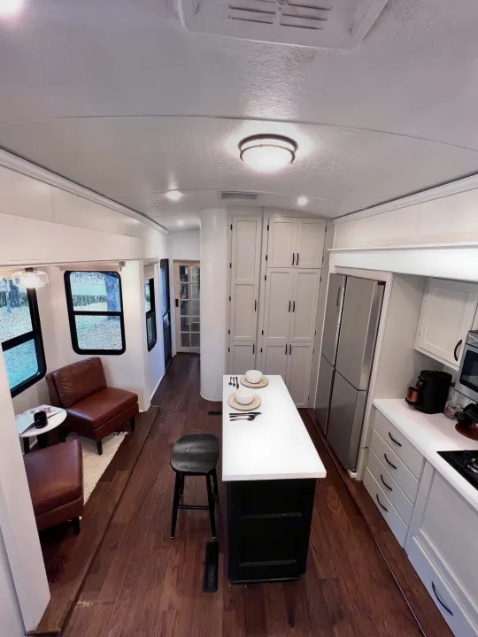 Spacious & modern RV rental interior featuring a kitchen, island dining, and comfortable living area. Perfect for your next adventure!. Keystone RV Montana 2015