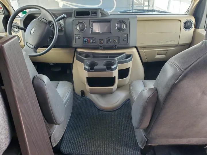 RV rental cockpit view: Ford E-Series dashboard with multimedia screen, steering wheel, and comfortable gray seats.. Forest River Sunseeker 2020
