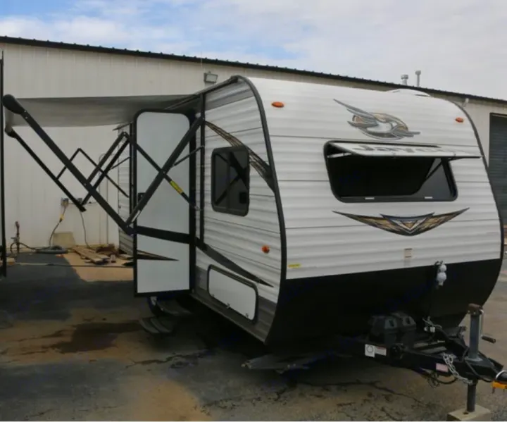 This travel trailer RV rental features an extended awning, open door, and front hitch, ready for your next adventure.. Jayco Jay Flight SLX 184 BS 2019