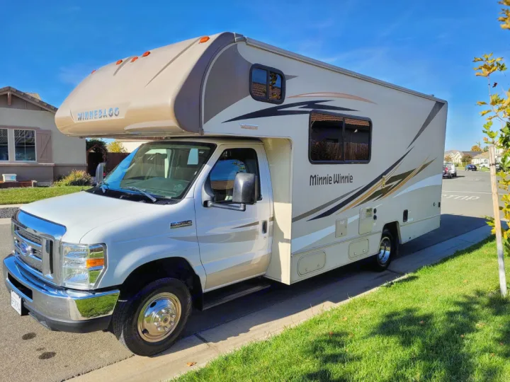 White & beige Winnebago Minnie Winnie RV rental parked on a sunny residential street. Ready for your road trip adventure!. Winnebago Minnie Winnie 2018