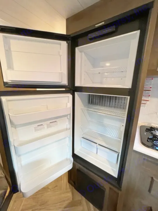 Spacious Dometic RV rental refrigerator with open freezer and fridge sections, ready for your adventure.. Forest River EVO Select 268 BH 2022